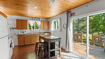 Une cuisine avec des meubles de rangement en bois, un four à micro-ondes et un évier.