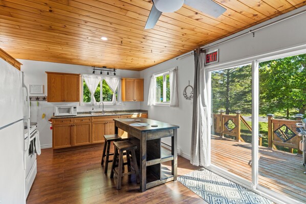 A kitchen with wooden cabinets, a microwave, and a sink.