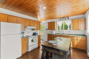 A kitchen with wooden cabinets, a white refrigerator, a stove, and a microwave.