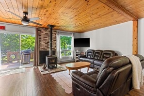 A cozy living room with a fireplace, leather sofa, and a flat-screen TV.