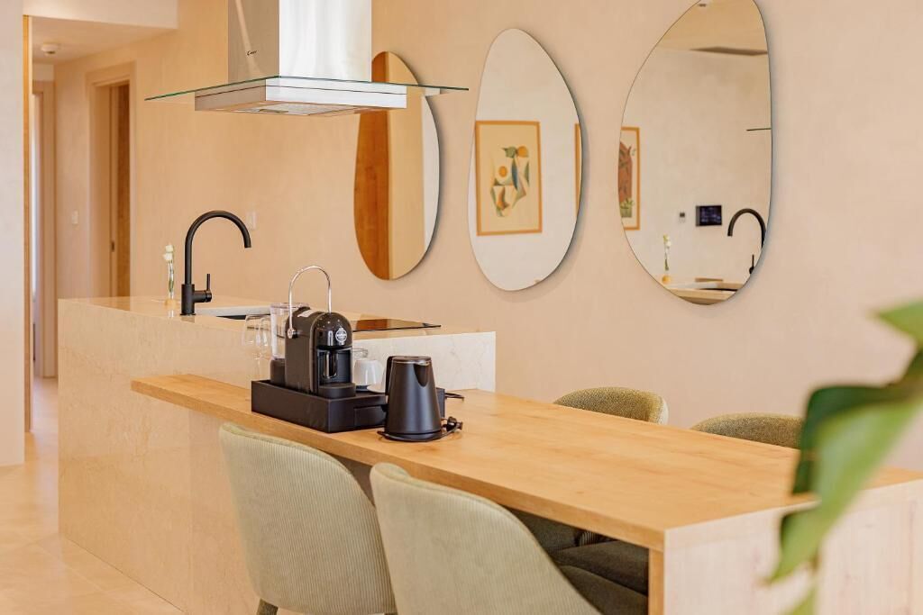 A modern kitchen with a central island, a coffee maker, and a sink.