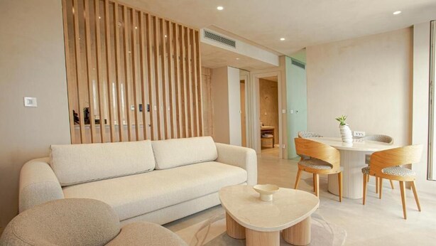 Un salon moderne avec un canapé, une table basse ronde et des chaises en bois.