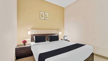 Habitación de hotel con una cama grande, una mesita de noche, una lámpara y un cuadro en la pared.