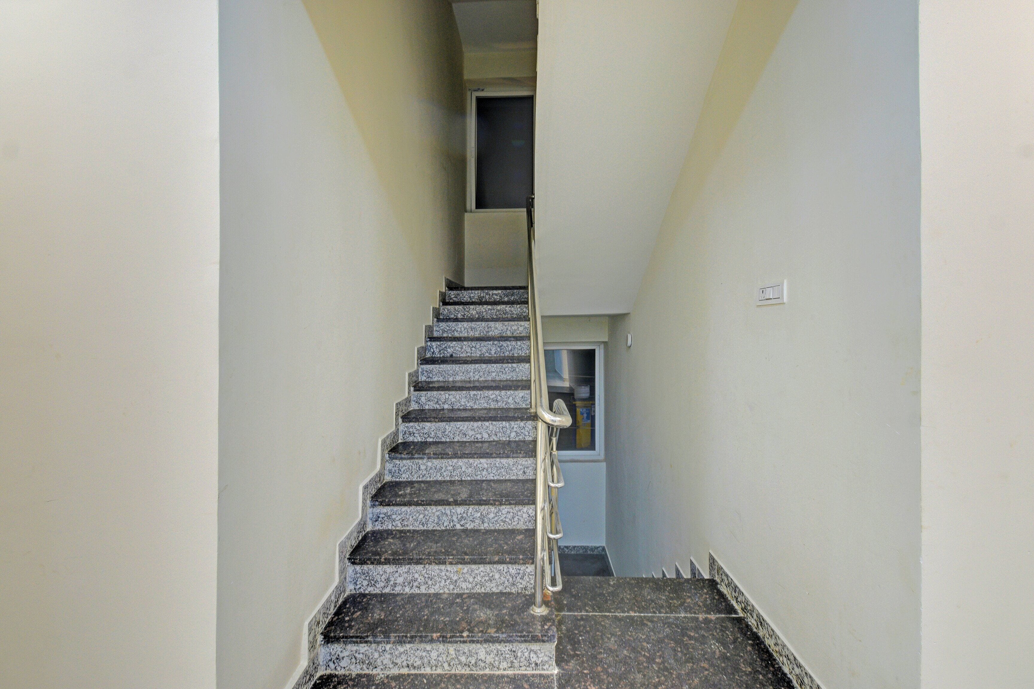 Un escalier étroit doté d’une rampe menant à un palier.