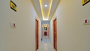 A hotel corridor with doors marked with room numbers, a polished floor, and recessed lighting. - Super Collection O Hyderabad Central (Hyderabad)