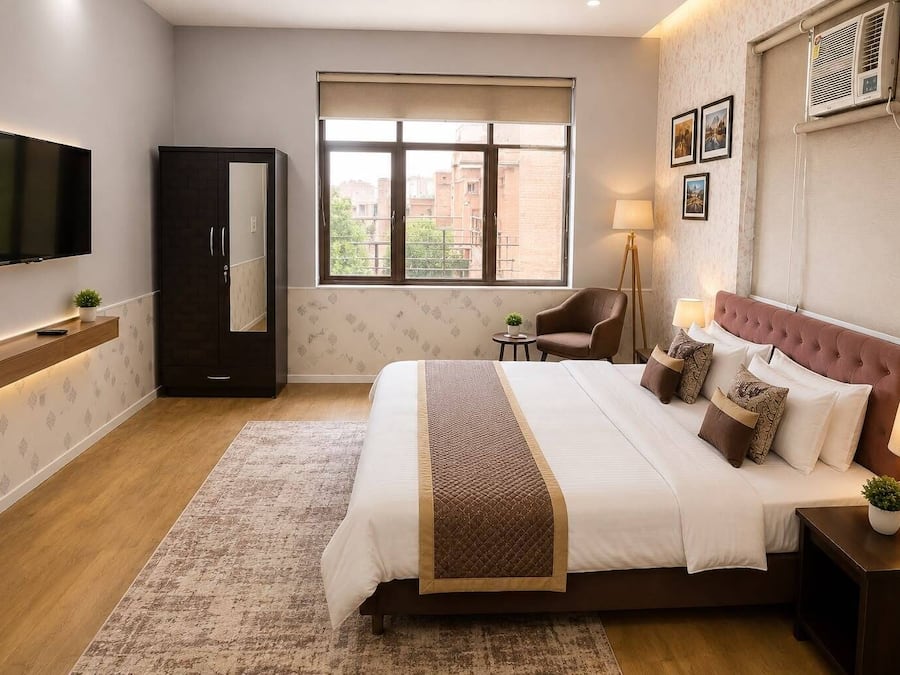 Una habitación de hotel con cama, mesitas de noche, televisor, armario, ventana y lámpara.