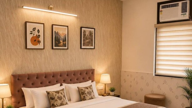 A bedroom with a large bed, two bedside lamps, a ceiling fan, and framed artwork on the wall. - Heistel Delhi (New Delhi)