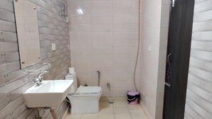 A bathroom with a sink, toilet, and a mirror. - Heistel Delhi (New Delhi)