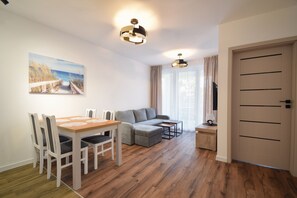 Una sala de estar moderna con una mesa de comedor, sofá y un cuadro en la pared.