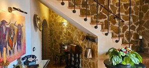 A staircase with a stone wall and a hanging light fixture.