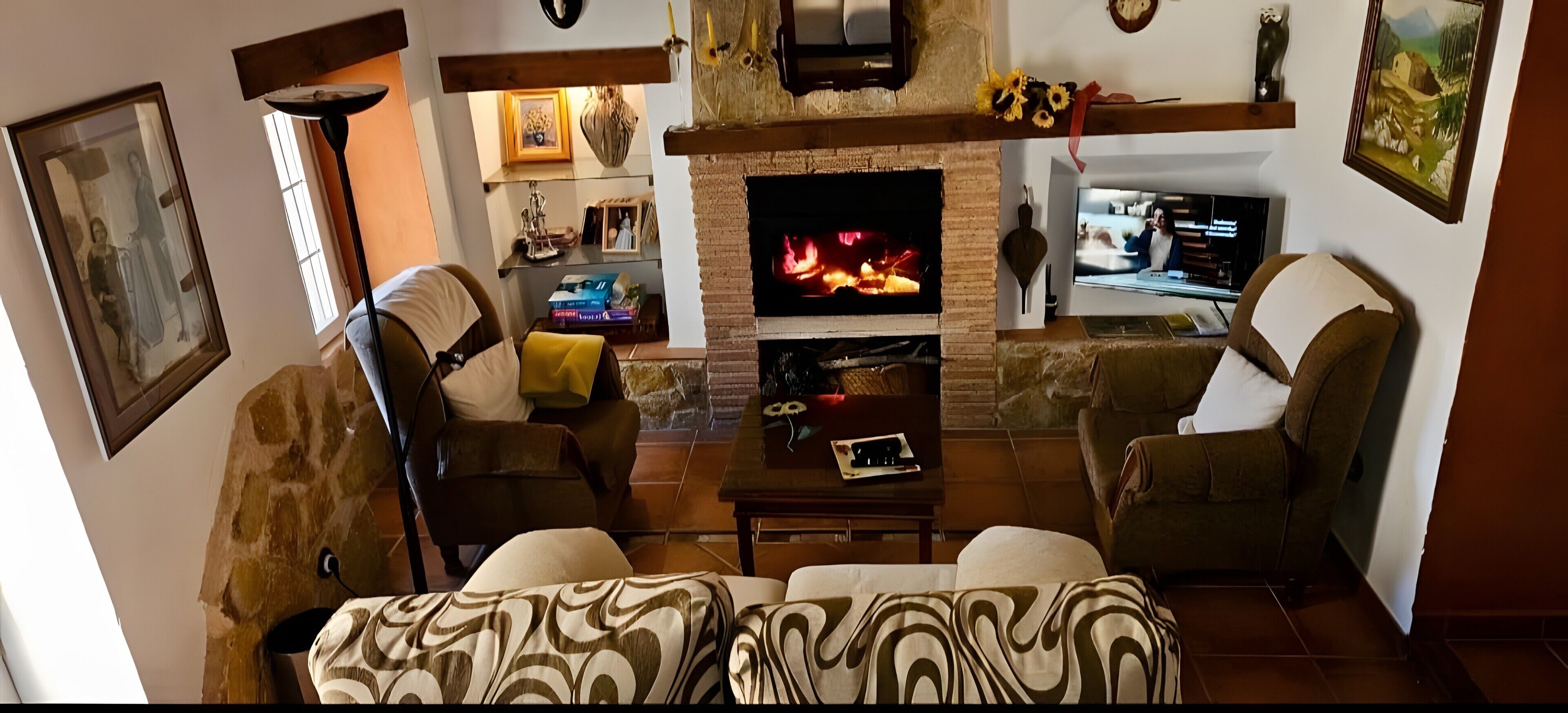 A cozy living room with a fireplace, comfortable seating, and a television.