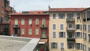 Een meerlaags gebouw met balkons, een bord waarop een restaurant aangegeven staat, en een heldere lucht.