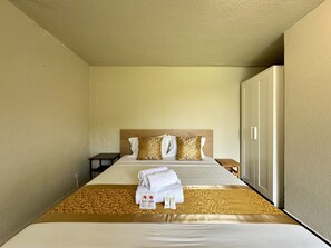 A hotel room with a bed, a nightstand, a wardrobe, and a towel and toiletries on the bed. - Vilamoura Browns Villa by Homing (Loulé)