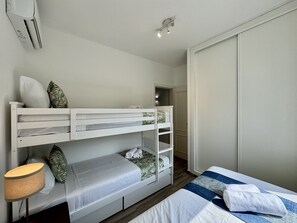 A bunk bed with storage drawers, a bedside lamp, and a wardrobe. - VILAMOURA BROWNS VILLA WITH POOL by HOMING (Vilamoura)