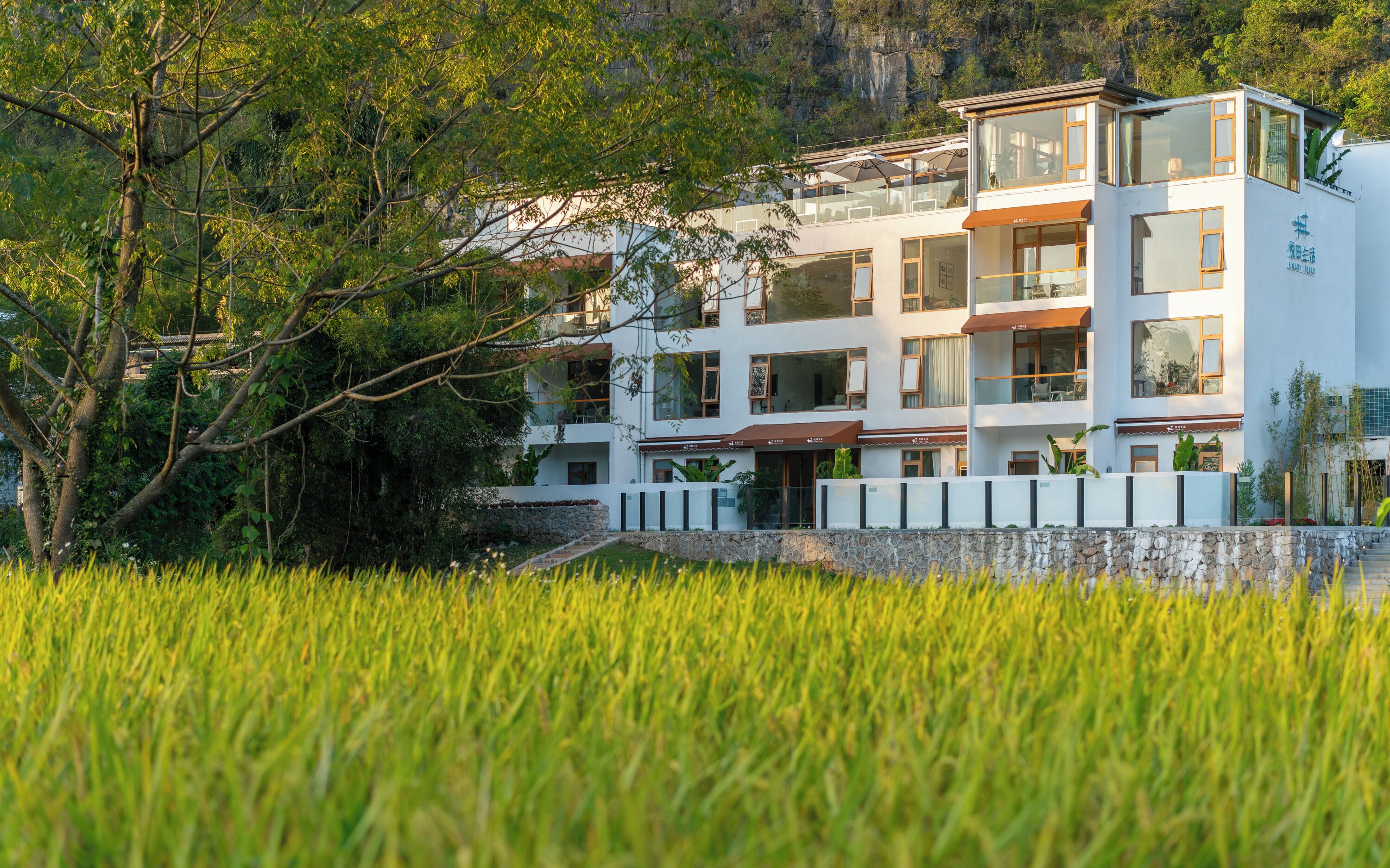A multi-story hotel with a modern architectural design, featuring balconies and large windows.