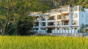 Un hotel de varios pisos con un diseño arquitectónico moderno, que cuenta con balcones y grandes ventanales.