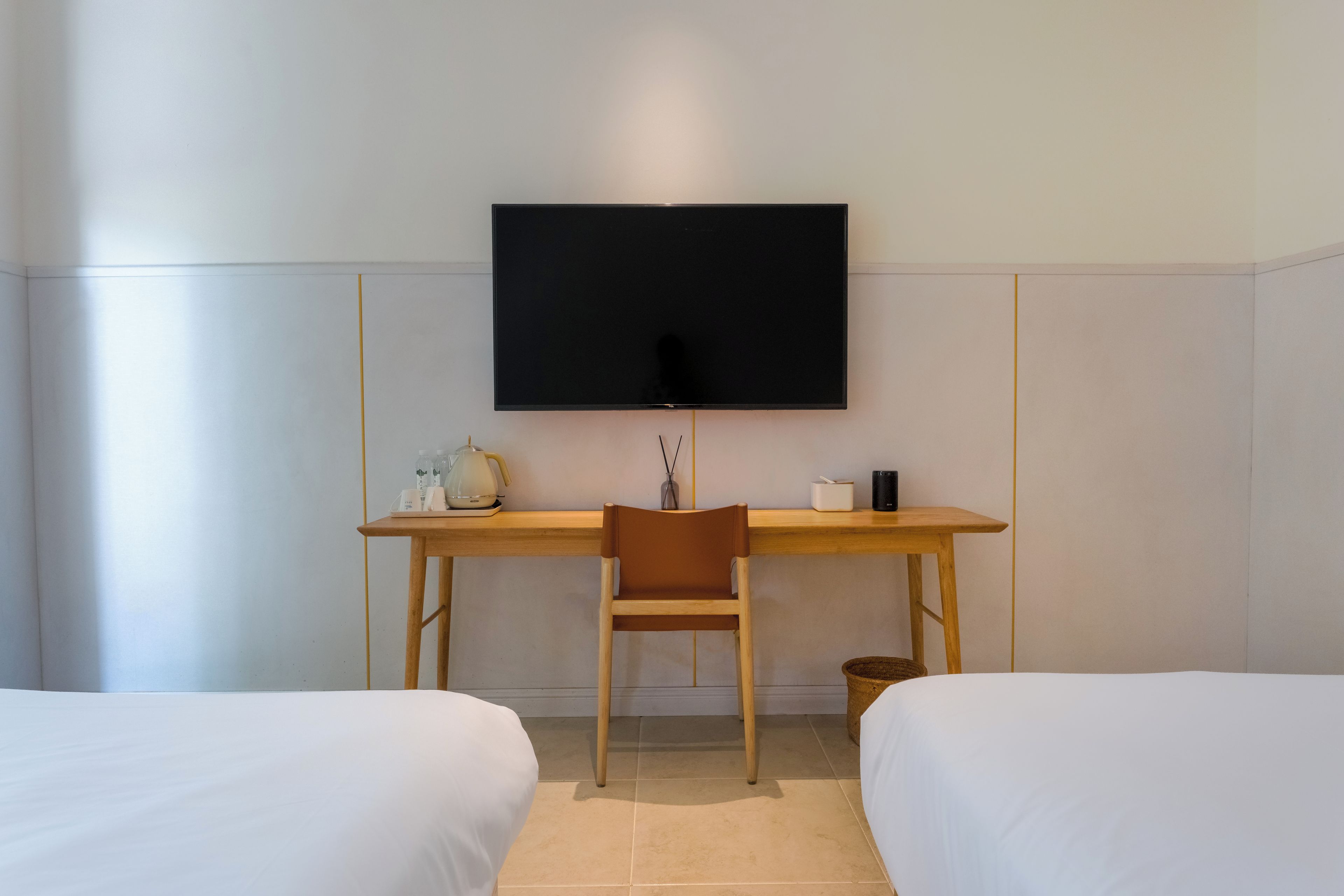 Ein Hotelzimmer mit Bett, Schreibtisch mit Stuhl, Fernseher und Nachttisch.