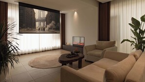 A modern living room with a large flat-screen TV, a fireplace, and comfortable seating.
