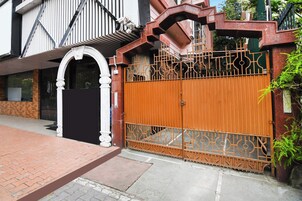 A gated entrance with a decorative metal gate and a white archway.