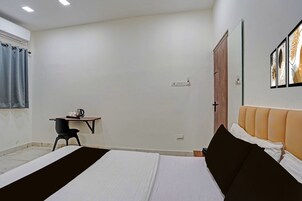 Un dormitorio con cama, escritorio, silla y armario.