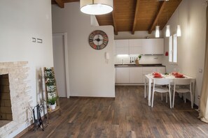 A modern kitchen with white cabinets, a wooden ceiling, and a dining area with a white table and chairs. - Villa 10 minutes from Piscina Rei beach (Castiadas)