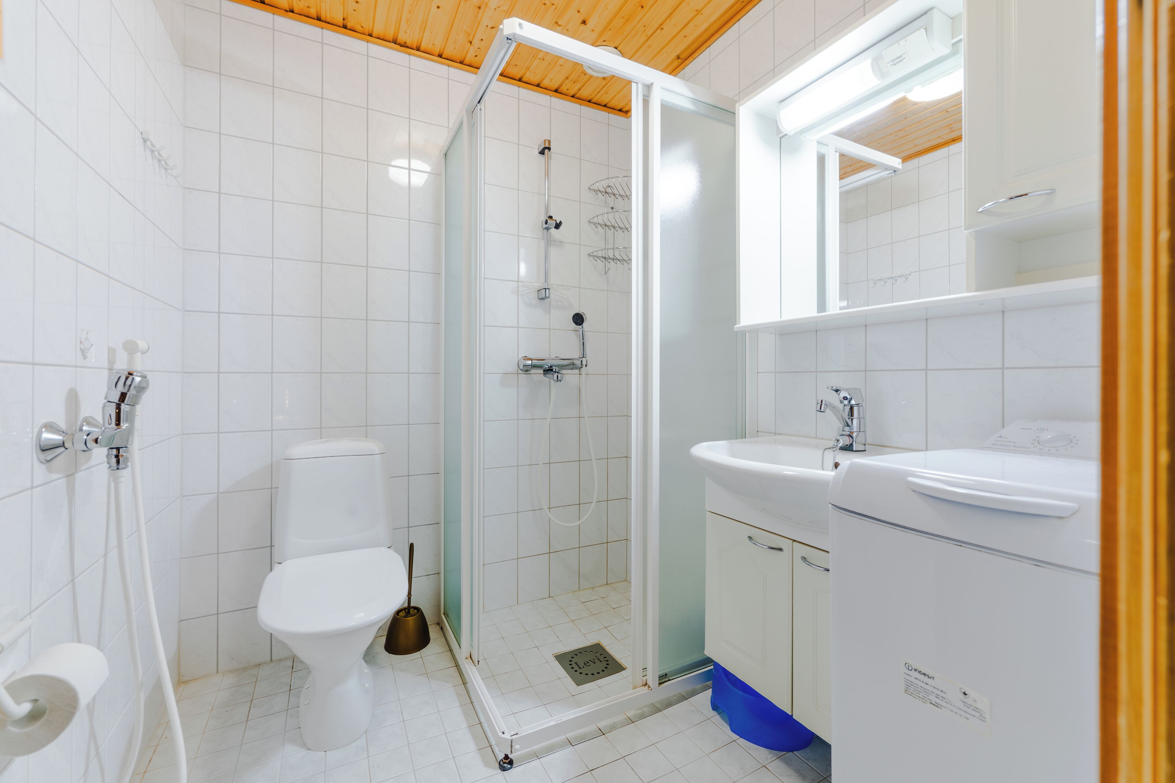 A modern bathroom with a toilet, shower, and sink.