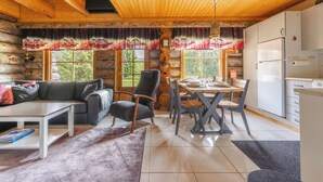 A log cabin interior with a dining area, kitchen, and living space. - Villa Mäkitupa (Kittilä)