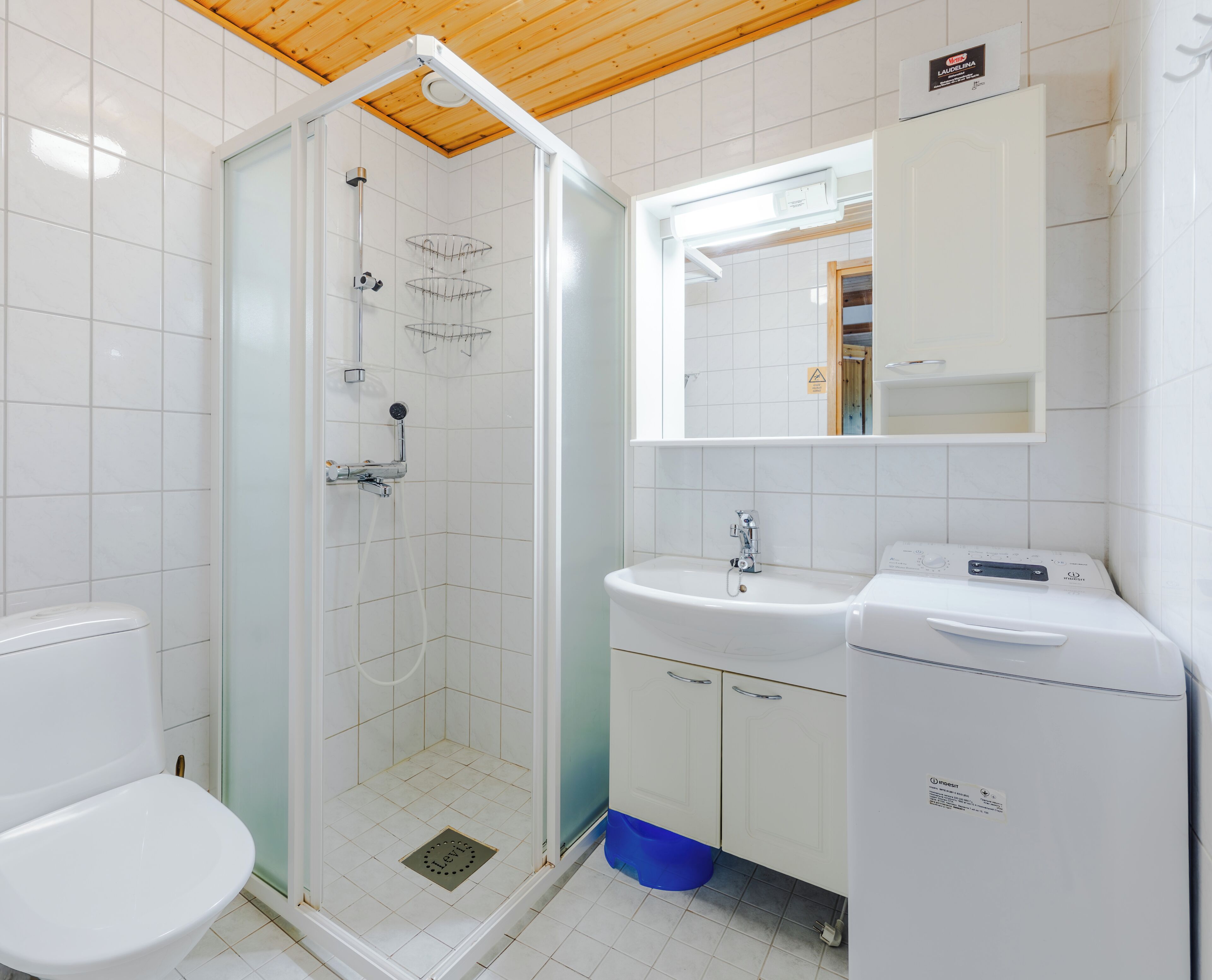 A bathroom with a shower, toilet, sink, and a mirror above the sink.