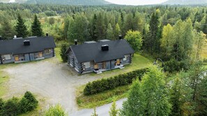 A cabin-style lodging with a gravel driveway and a well-maintained lawn.