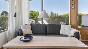 Ein Zimmer mit einer Couch, einem Tisch und einer Hängelampe.