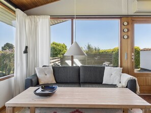 Ein Zimmer mit einer Couch, einem Tisch und einer Hängelampe.