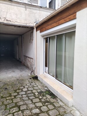 A narrow alleyway with a cobblestone path leading to a building entrance. - Studio in the heart of Fontainebleau (Fontainebleau)