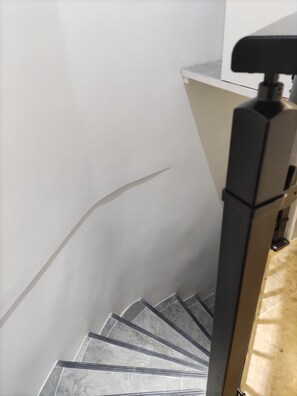 A staircase with a handrail and a wall with a visible crack. - Studio in the heart of Fontainebleau (Fontainebleau)
