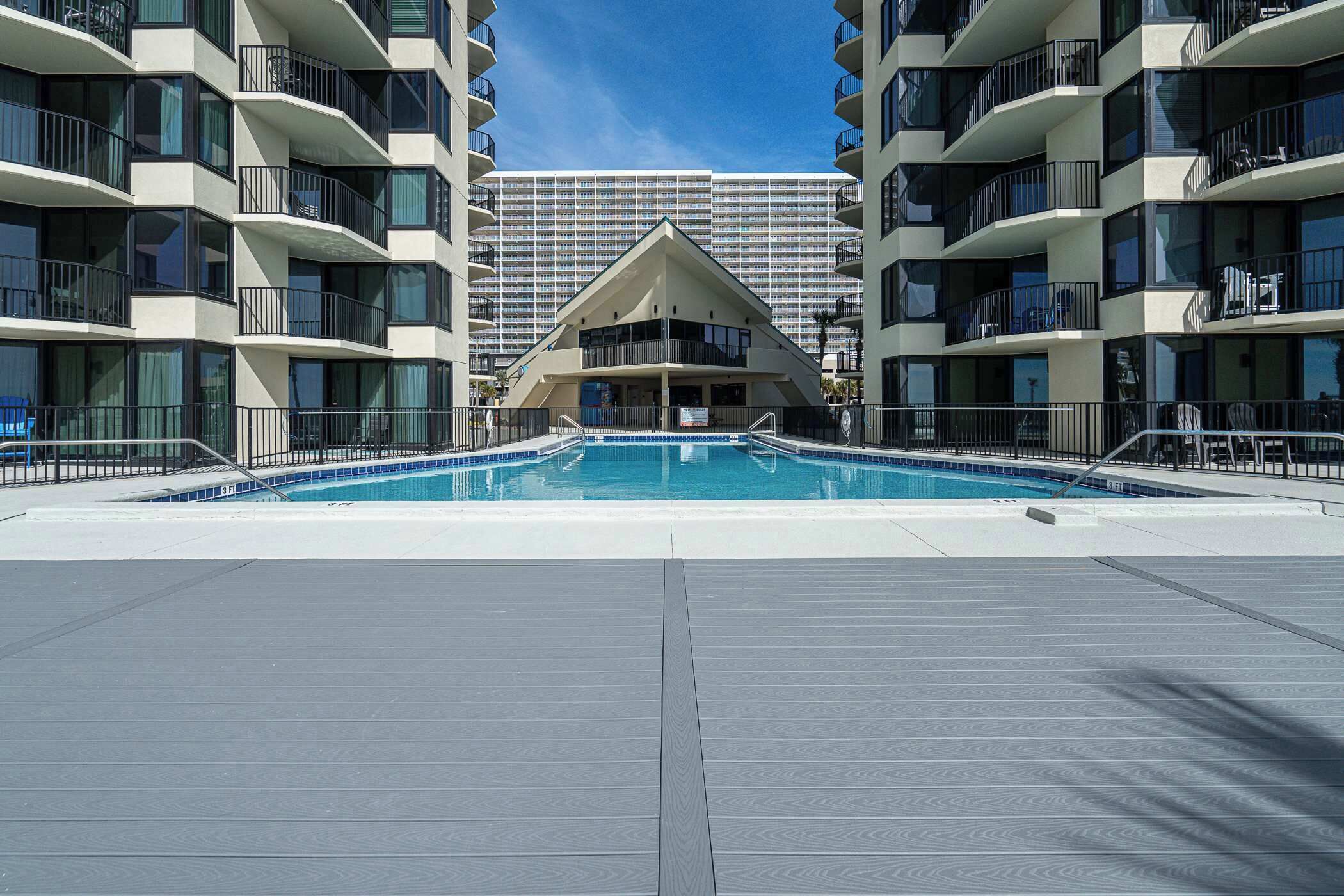 A swimming pool surrounded by multi-story buildings with balconies.