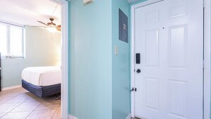A bedroom with a bed, a ceiling fan, and a window with blinds. - Coastal Bliss Beachfront Resort Oasis for 5! (Panama City Beach)
