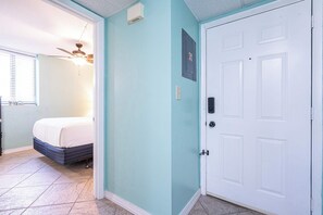 A bedroom with a bed, a ceiling fan, and a window with blinds. - Coastal Bliss Beachfront Resort Oasis for 5! (Panama City Beach)