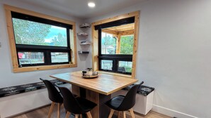 A room with a wooden table, four chairs, and two windows with wooden frames. - Lofted home in a quiet neighborhood of downtown Salida. California king bed plus super comfortable queen murphy bed and FullXL floor mattress in loft. Two levels, two bathrooms, beautifully landscaped private courtyard with hot tub and gas fire pit. (Salida)