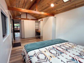 Een slaapkamer met een bed, een bureau en een kledingkast.
