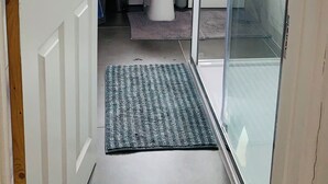 Ett modernt badrum med toalett, handfat och dusch med glasväggar.
