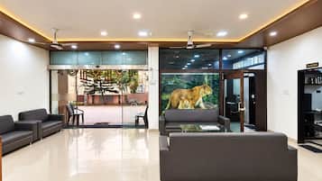 Un vestíbulo moderno con entrada de vidrio, zona de estar y un gran mural de un león.