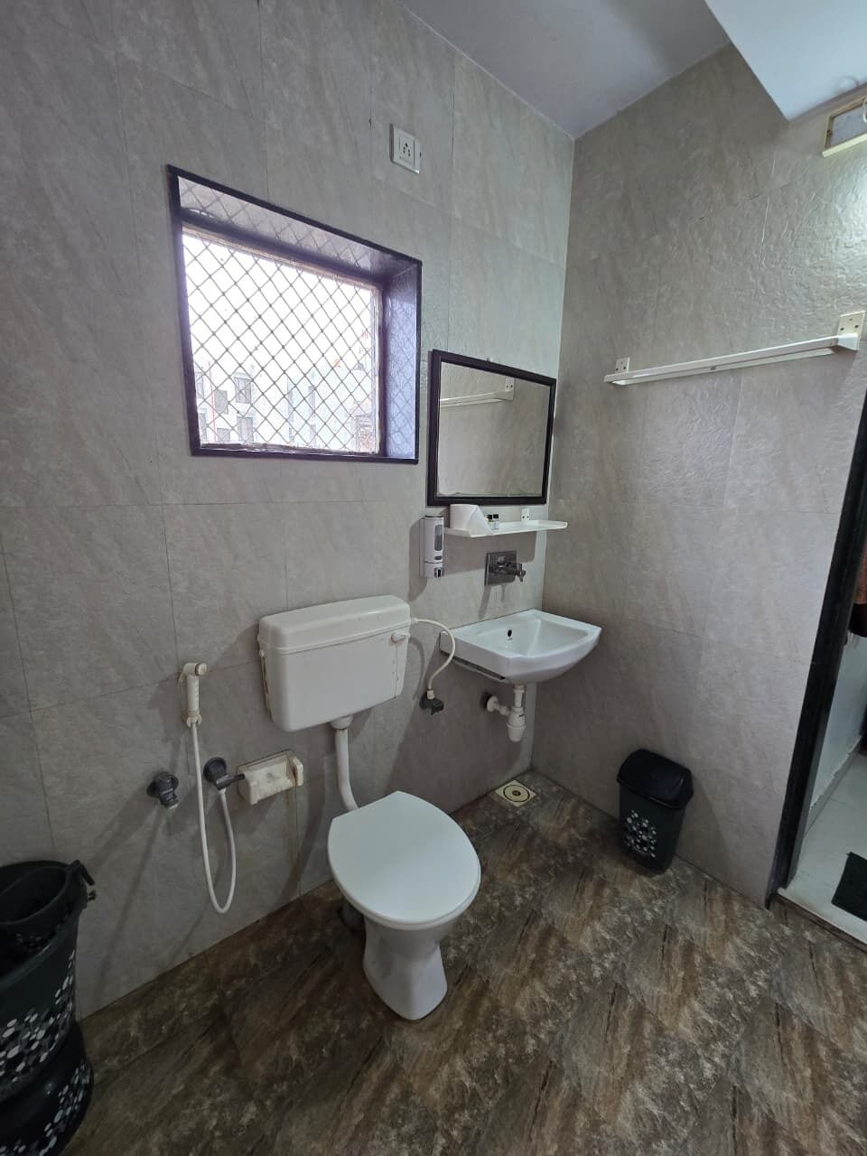 A bathroom with a toilet, sink, and window.