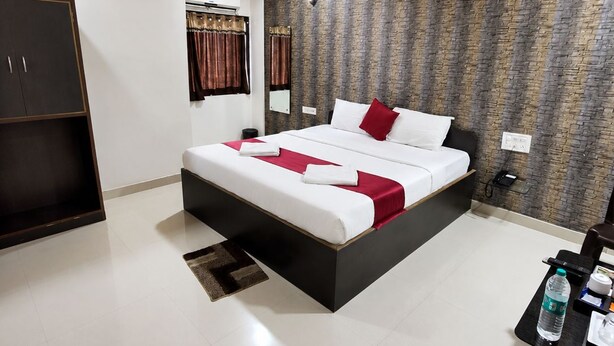 Une chambre d’hôtel moderne dotée d’un grand lit, d’une armoire, d’un bureau avec une chaise et d’une salle de bain avec douche.
