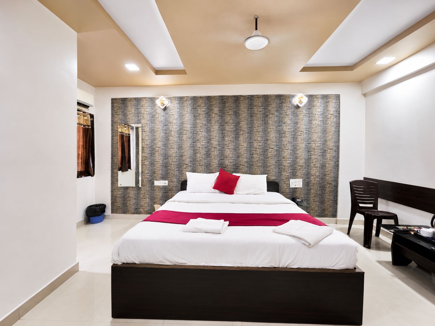 Una habitación de hotel moderna con una cama grande, un escritorio y una silla.