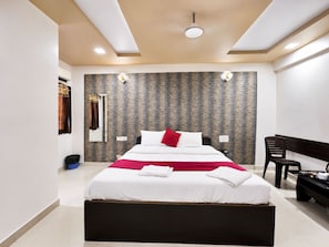 Una habitación de hotel moderna con una cama grande, un escritorio y una silla.