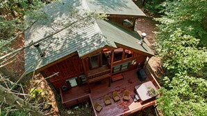 A cabin with a porch, a deck, and a covered outdoor seating area. - 3 Brothers Bears | Smoky Mountain Escape (Sevierville)
