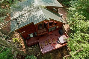 Uma cabana com varanda, terraço e área de estar coberta ao ar livre.