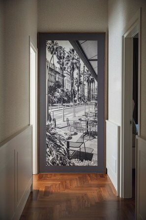 A hallway with a large framed black and white photograph of a street scene with palm trees and buildings.