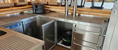 Une cuisine de taille réduite équipée d’un lave-vaisselle encastré, d’un réfrigérateur compact et d’une cuisinière à gaz.