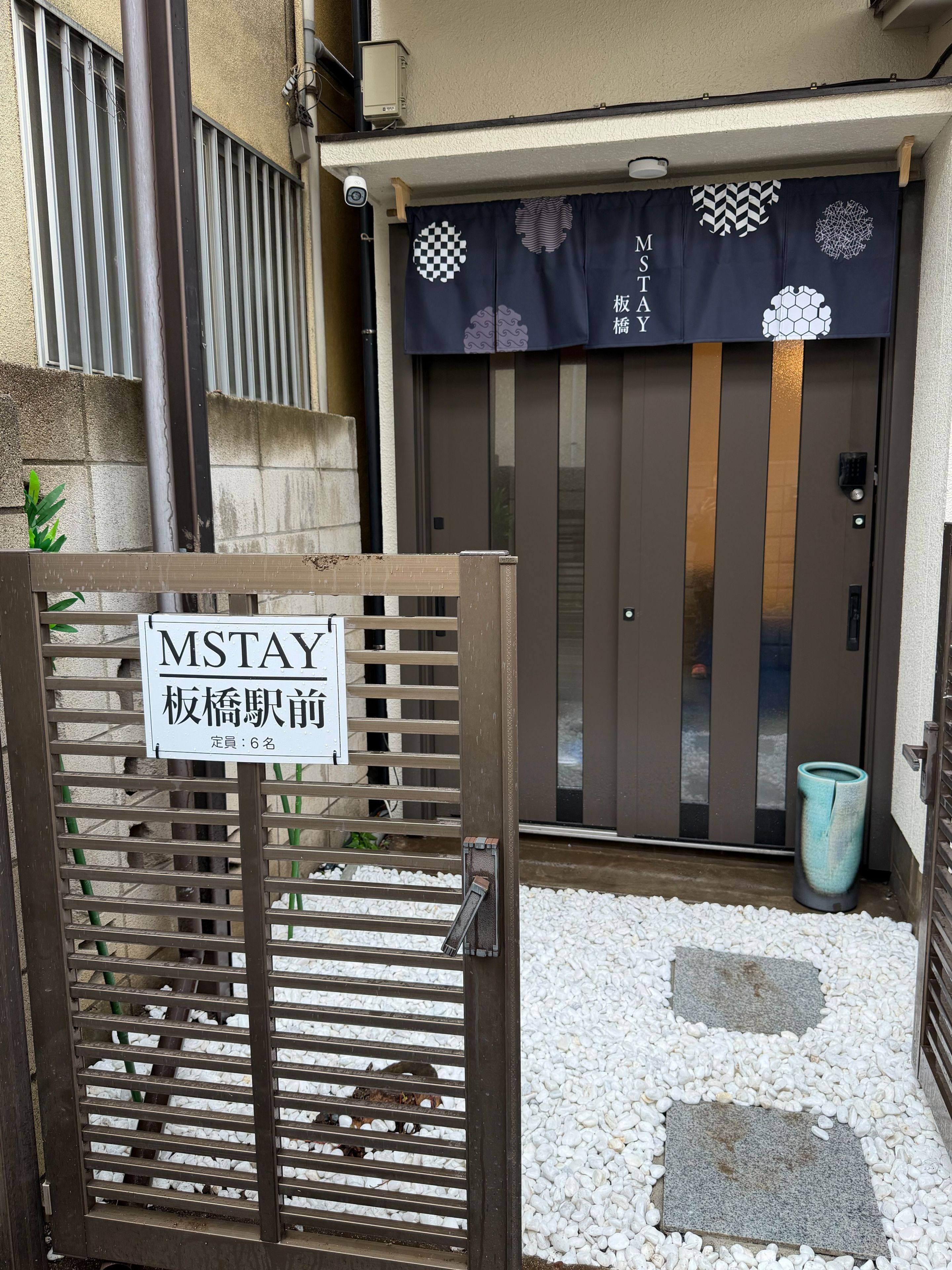 A gated entrance with a sign indicating a maximum stay of 6 persons.