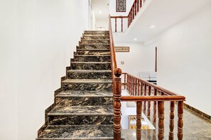 A marble staircase with wooden balusters leading to a landing. - Collection O Dal Lake (Srinagar)